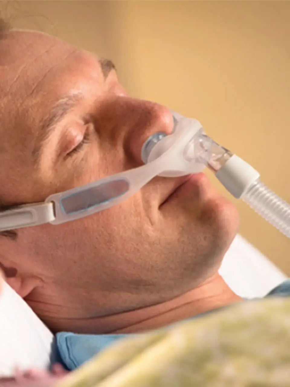 https://cdn.shopify.com/s/files/1/0318/9771/4819/files/Man-Sleeping-With-CPAP-Naunce-Nasal-Mask.webp?v=1732298408
