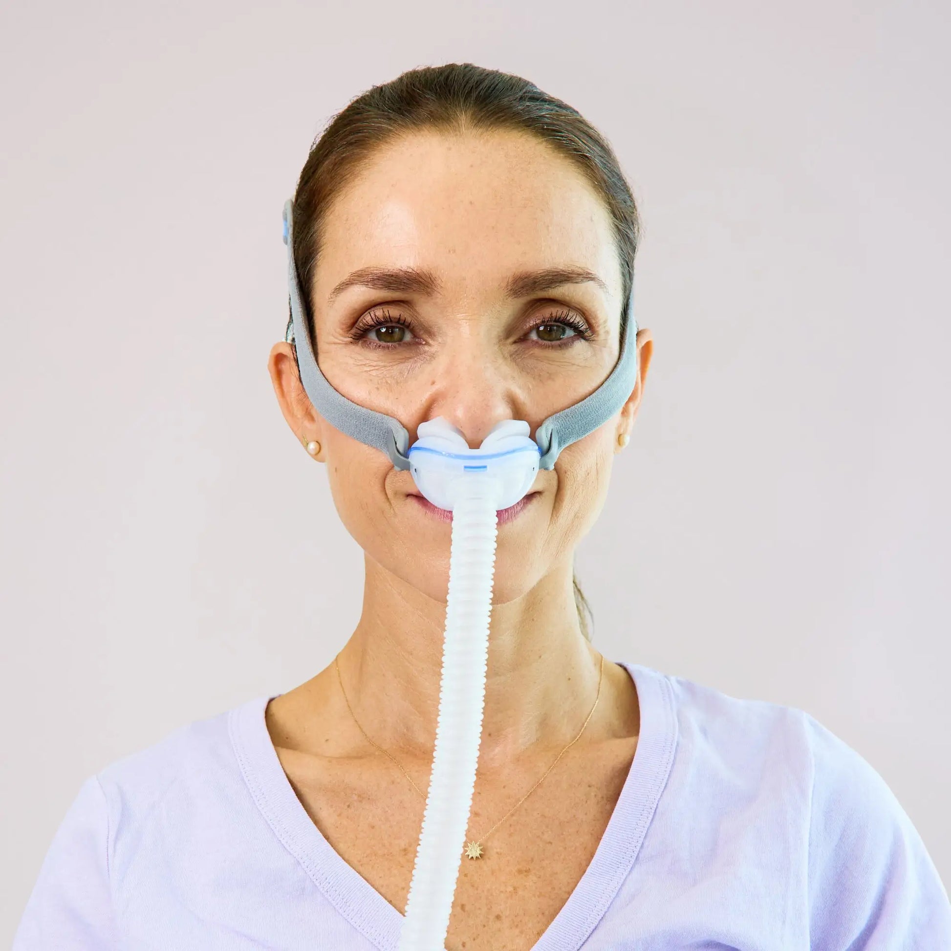 https://cdn.shopify.com/s/files/1/0318/9771/4819/files/woman-using-the-resmed-airfit-p10-nasal-cpap-mask-front-view.webp?v=1745261538